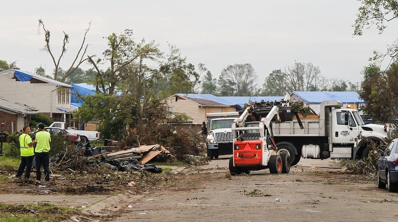 Workers continued to clear tornado debris along Olive Tree Drive in Trotwood on Wednesday. CHRIS STEWART / STAFF