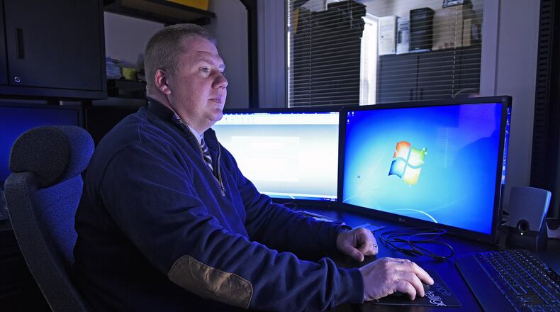 Miami University Police Department Detective Walt Schneider surrounded by monitors and specialized equipment in his Oxford office. Schneider, a digital forensic examiner, has been trained by the Secret Service. He helps agencies from Butler County and beyond who need help gathering evidence in cyber crimes.
