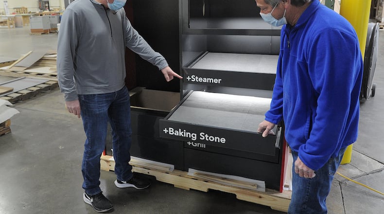 Brett Holdman, left and James Ashworth, look over the KitchenAid Smart Oven display that the c pathe company manufactures. MARSHALL GORBY\STAFF