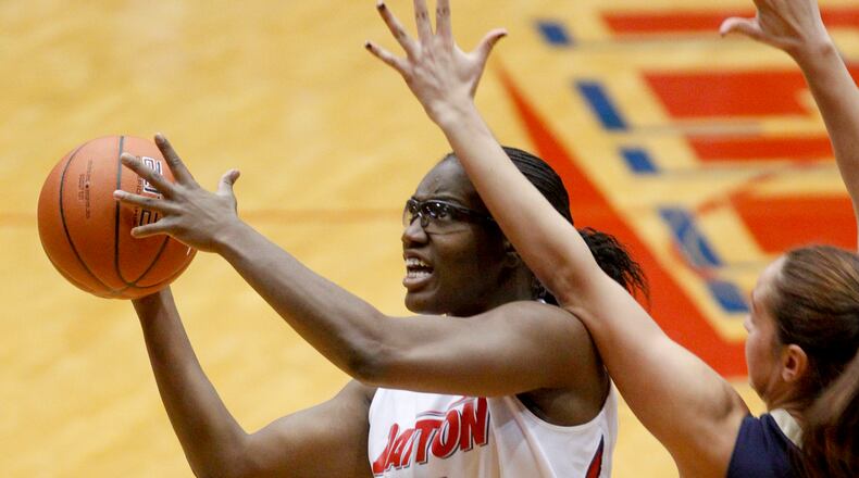 The University of Dayton's Olivia Applewhite (4) drives to the basket against George Washington University's Sara Mostafa Thursday at UD Arena. UD beat George Washington 80-52. STAFF PHOTO BY LISA POWELL