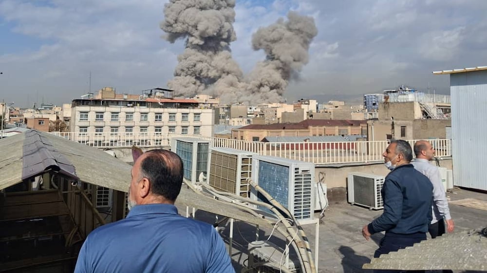 People watch as smoke rises on the skyline after an explosion in Tehran, Iran, Saturday, Feb. 28, 2026.(AP Photo)