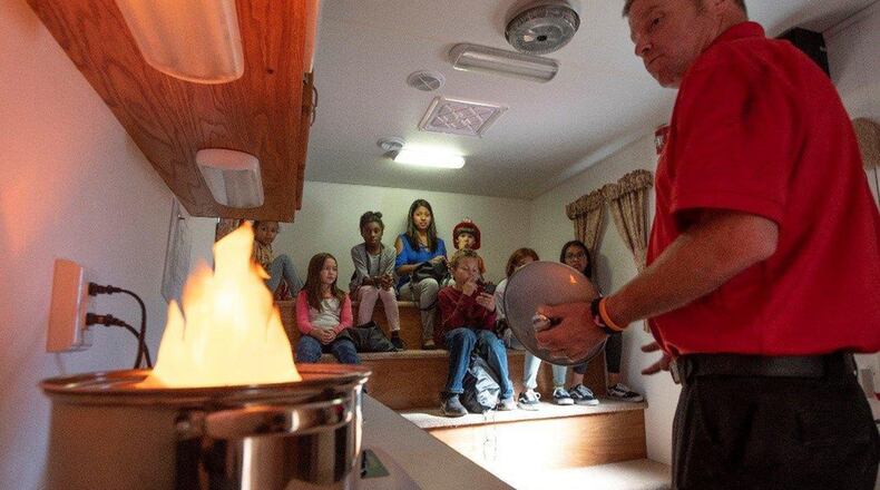 Stephen Hughes, 788th Civil Engineer Fire Department firefighter, performs a safety demonstration for children during a Fire Prevention Week event Oct. 4 at the Prairies Child Development Center, Wright-Patterson Air Force Base. The WPAFB fire department and the 88th Force Support Squadron partnered with other local fire departments to host this event in an effort to raise fire awareness and to decrease causalities caused by fires. (U.S. Air Force photo/Michelle Gigante)