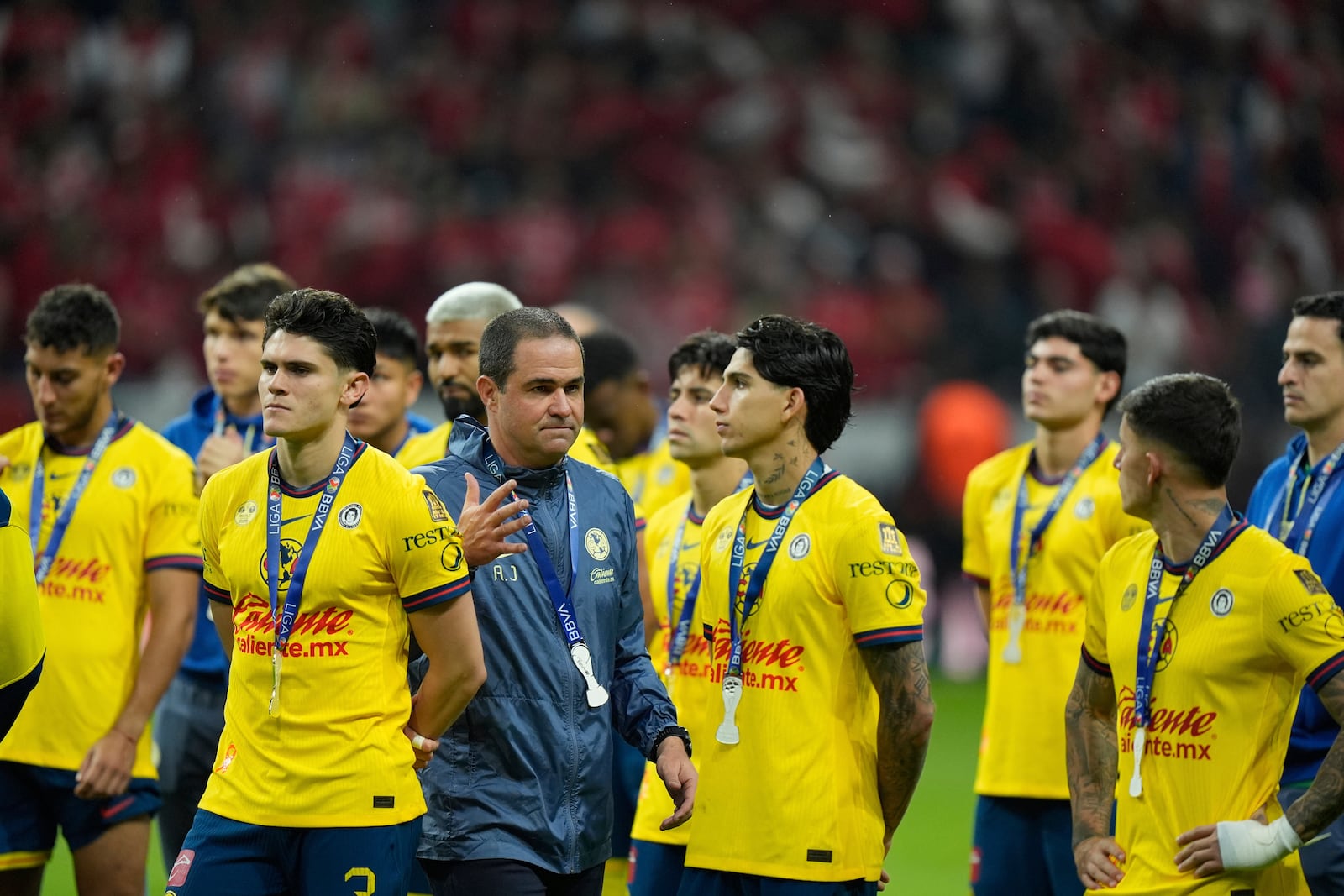 America's coach Andre Jardine and his players stand on the pitch with their second place medals after losing 0-2 against Toluca during the Mexican soccer league second leg final match at Nemesio Diez stadium in Toluca, Mexico, Sunday, May 25, 2025. (AP Photo/Fernando Llano)