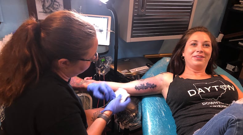 Since the Aug. 4 shooting in the Oregon District, local residents have flocked to local tattoo parlors  to get some type of love note to Dayton. STAFF/CORNELIUS FROLIK