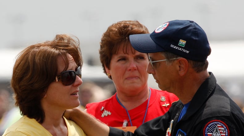 7-28-07--Photo by Ty Greenlees-- 14:46:44 Jim LeRoy's wife Joanie LeRoy, left, is comforted by air show announcer Rob Reider, right, after Jim crashed into runway 24R during his performance with Skip Stewart.