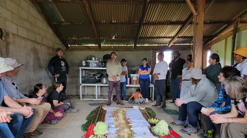 A traditional pambamesa with the local Andean indigenous community. Food is provided by all and spread on the sheet; cabbage leaves are used to hold the food.