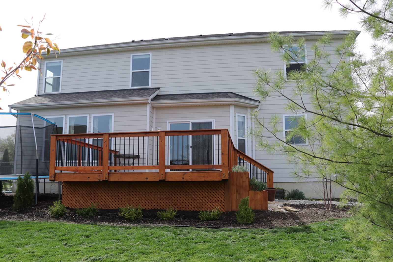 Patio doors from the breakfast room open to the deck with built-in tiered flower boxes. The deck leads down to stone walkways and a fenced back yard. The back yard extends past the fence line. CONTRIBUTED PHOTO BY KATHY TYLER