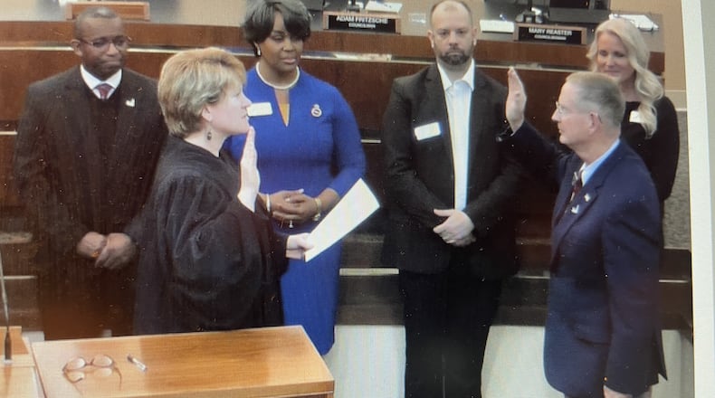 Fairborn Mayor Dan Kirkpatrick (front right) is sworn in Monday night by municipal court Judge Beth Cappelli as city council members look on. NICK BLIZZARD/STAFF