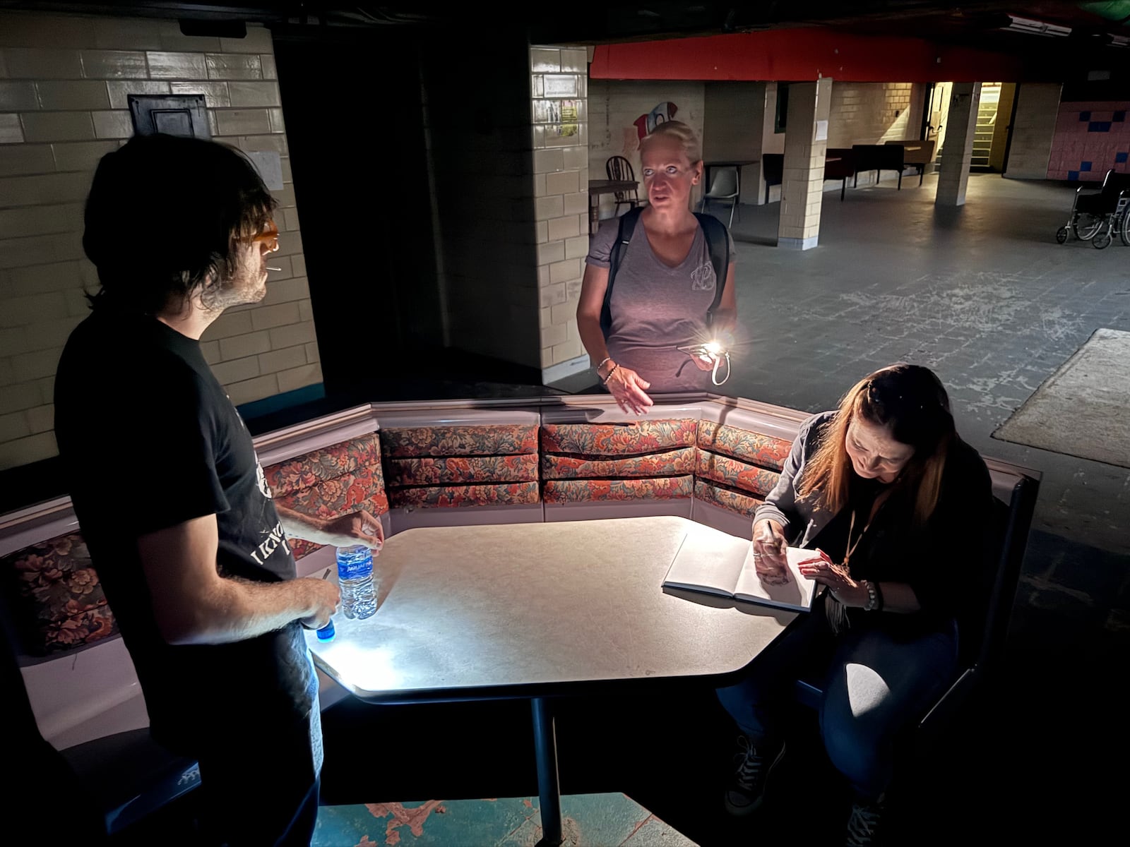 Brandon Berry (left) gets a history lesson on school hauntings from Paula Dytko (middle), while Bronwyn Blanc (right) channels external forces onto paper. CONTRIBUTED/ADAIR TUDOR