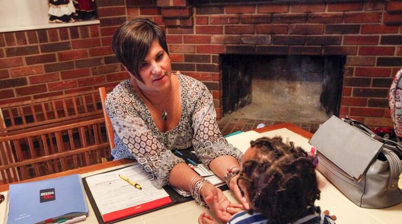 Montgomery County Children Services caseworker Janine Elders visits a child in custody currently receiving foster care from Patricia Boring. Elders, with Children Services 22 years, now works with foster parents but spent her first years on the job working directly with families in crisis. She said she was able to cope that long by not taking work home with her. CHRIS STEWART / STAFF