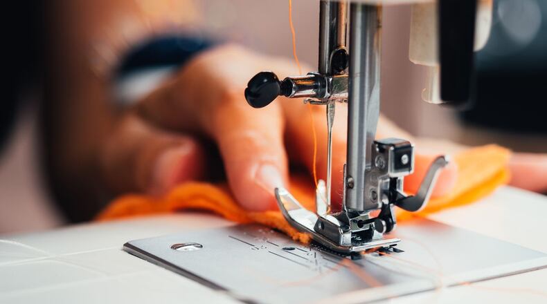 Stock photo of a woman using a sewing machine.