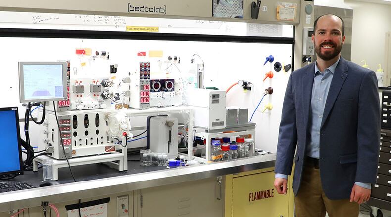 Dr. Luke Baldwin, chemical research scientist and a member of the Air Force Research Laboratory’s Materials and Manufacturing Directorate, stands with with the flow chemistry machine. U.S. AIR FORCE PHOTO/JONATHAN TAULBEE
