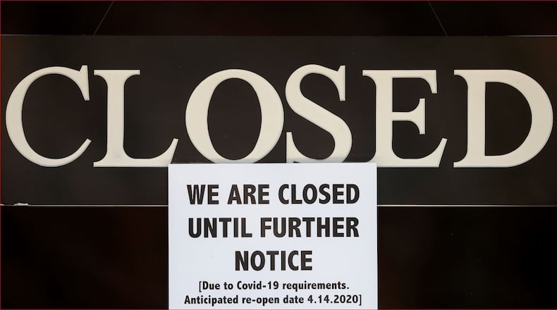 In this April 2, 2020 file photo, a notice of closure is posted at The Great Frame Up in Grosse Pointe Woods, Mich. (AP Photo/Paul Sancya, File)