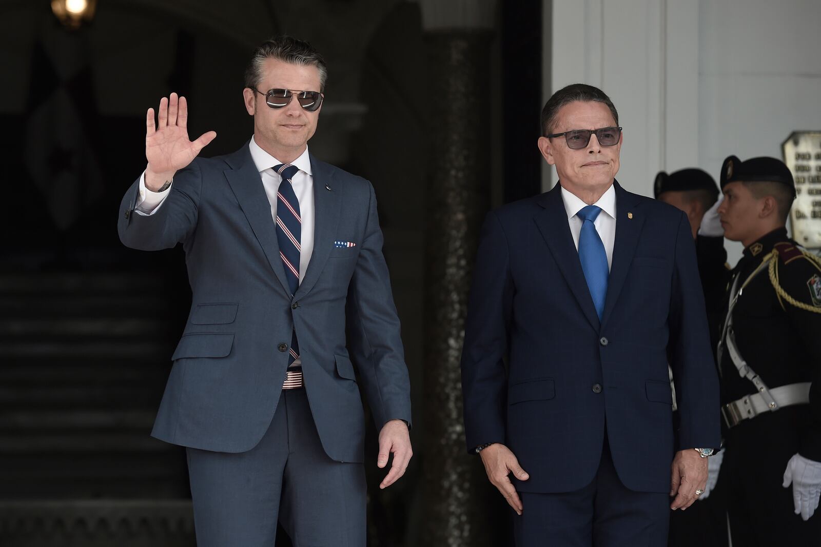 US Secretary of Defense Pete Hegseth, left, waves to the press with Panamanian Minister of Security Frank Abrego before a meeting with Panamanian President Jose Raul Mulino at the presidential palace in Panama City, Tuesday, April 8, 2025. (AP Photo/Agustin Herrera)