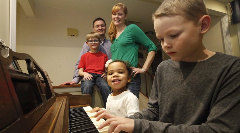 Megan and Kraig Neer of Dayton have been foster parents to several children, including their now-adopted daughter Mia, 2, who joined brothers Kaleb, 8, playing piano, and Blake, 5. CHRIS STEWART / STAFF