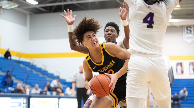 Shawnee High School senior Desmond Houseman drives to the basket against Thurgood Marshall's Chasaun Little (4) and Renald Person III during their game on Wednesday night at Springfield High School. The Braves won 50-45. Michael Cooper/CONTRIBUTED