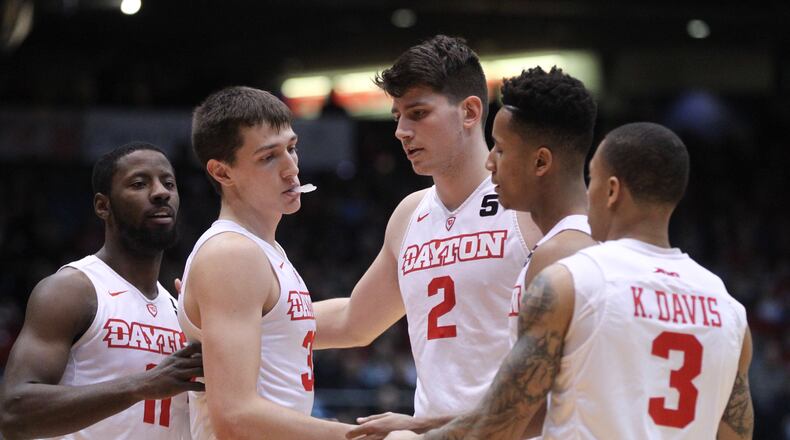 Dayton player (left to right) Scoochie Smith, Ryan Mikesell, Sam Miller, Darrell Davis and Kyle Davis huddle during the first half against VMI on Friday, Dec. 23, 2016, at UD Arena. David Jablonski/Staff
