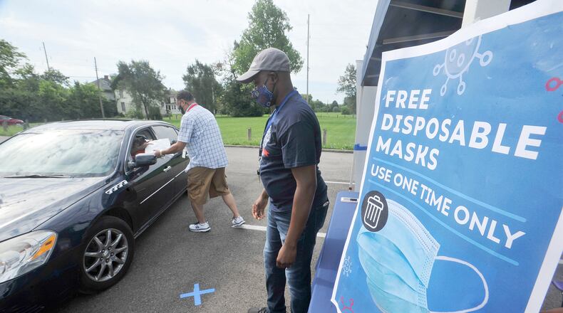 John Payne, left and Gilbert Ghand, with Dayton & Montgomery Public Health, help to giveaway free disposable mask Monday, Aug. 17, 2020, at the Mount Olive Baptist Church. MARSHALL GORBY\STAF