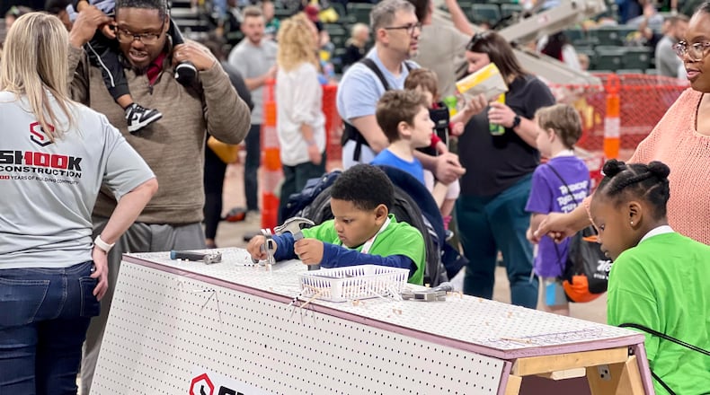 Siblings Michael Williams, center, and Heavenlee Williams, right, play at an installation during Sunday's Big Hoopla STEM Challenge held at the Nutter Center. AIMEE HANCOCK/STAFF