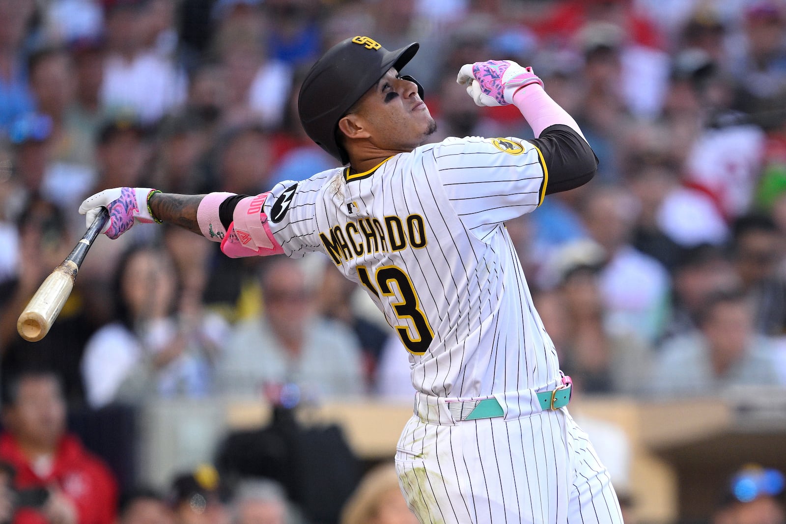 San Diego Padres' Manny Machado hits a sacrifice fly to score Fernando Tatis Jr. during the seventh inning of a baseball game against the Philadelphia Phillies, Saturday, July 12, 2025, in San Diego. (AP Photo/Orlando Ramirez)