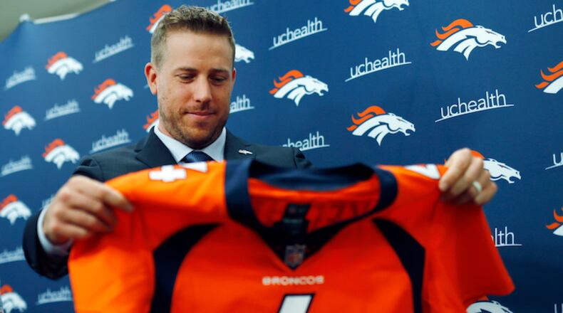 Case Keenum looks over his new jersey during a news conference to introduce him as the new starting quarterback of the Denver Broncos at the team's headquarters Friday, March 16, 2018, in Englewood, Colo.  (AP Photo/David Zalubowski)