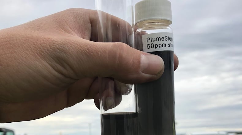 A worker compares a vile of Colloidal Activated Carbon, or PlumeStop, with a vile of water taken from a recently treated aquifer to ensure the PlumeStop was evenly distributed at a contaminated site at a Michigan Army National Guard base in February. PlumeStop is a relatively new method for treating the man made chemical known as PFAS and other contaminants in drinking water. The substance is injected into the ground and acts like a filter by removing the contaminants from the water for up to 60 years| Contributed