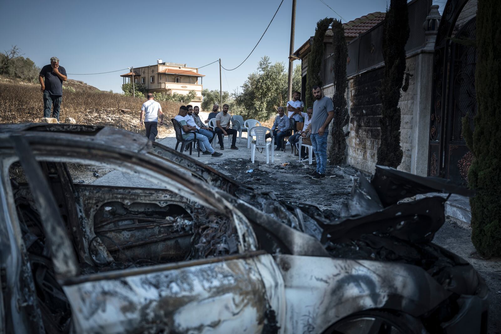 
                        People gather near burnt cars the day after an attack by Israeli settlers in the West Bank village of Jit, on Friday, Aug. 16, 2024. Residents of the village in the Israeli-occupied West Bank say one Palestinian man was killed by rampaging settlers. Israel’s military confirmed the village was attacked. (Sergey Ponomarev/The New York Times)
                      