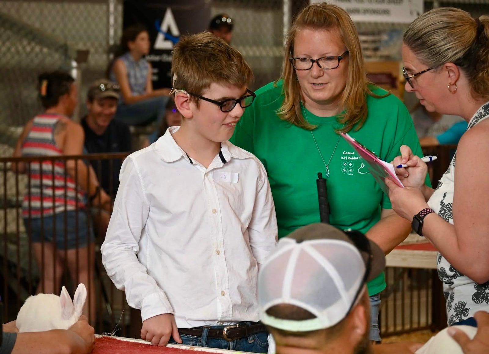 Gunner Lawson (center), a young boy who is blind and partially deaf, shows his rabbit at the Greene County Fair with the help of 4-H advisor Courtney Montgomery Monday, July 28, 2025. CONTRIBUTED 