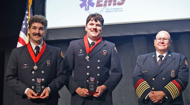 Springfield firefighters Robert Bloom, right, and Aaron Lopez pose for a picture with State Fire Marshal Kevin Reardon during the 43rd Annual Ohio Fire Service Hall of Fame and Fire Awards Wednesday, April 24, 2024 in Columbus. Bloom and Lopez received the Fire Service Valor Award for saving a baby from a townhouse that exploded last year. BILL LACKEY/STAFF