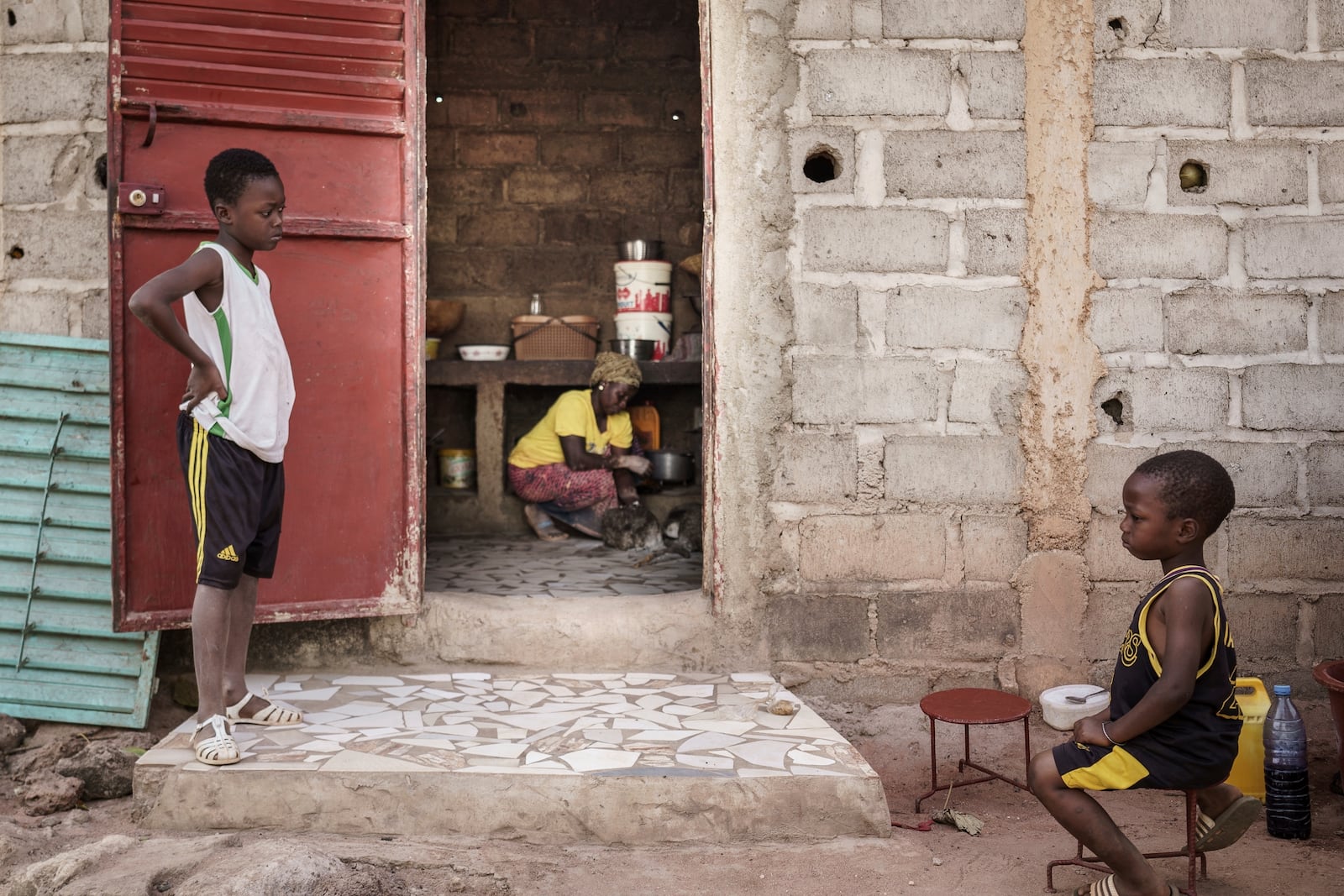 Children sit nearby as Sadio Camara, a gold processor, vaporizes mercury to separate and retrieve gold at her home in the Kedougou region of Senegal on Thursday, Jan. 16, 2025. (AP Photo/Annika Hammerschlag)