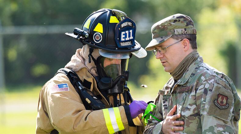 Paramedic Jared Spaeth of the 788th Civil Engineer Squadron Fire Department ties a ribbon around an Airman’s arm to mark his level of ‘wounds’ during a ‘fuel spill’ exercise May 19 at Wright-Patterson Air Force Base. Readiness exercises are routinely held to streamline unit cohesion when responding to emergencies. U.S. AIR FORCE PHOTO/WESLEY FARNSWORTH