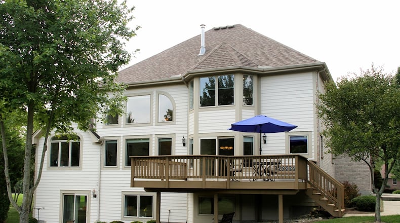 Panoramic views of the outdoor setting are enhanced with additional landscaping. A thick tree line edges the private back yard providing a peaceful view from its raised deck and both covered and open patios off the lower level. A fire pit is installed in a secluded area.