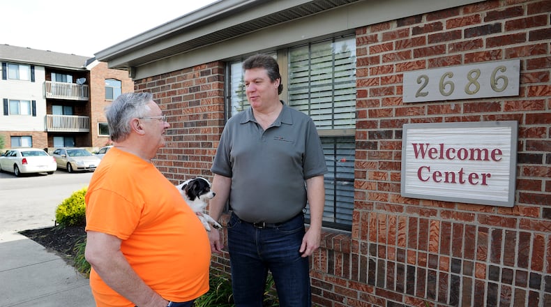 Cobblegate Square Apartments Property Manager Dave Cook, right, talks with resident Larry May and his dog, Panda, Friday morning June 17, 2022. MARSHALL GORBY\STAFF