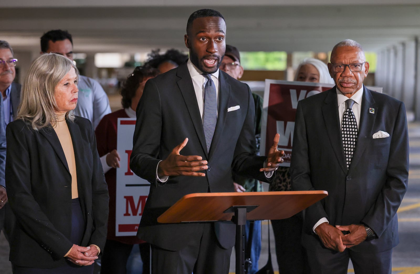 Dayton City Commission candidate Darius Beckham (center) talks while candidate Karen Wick (left) and mayor Jeffrey Mims Jr. listen during an early voting rally on Tuesday, Oct. 7 outside the Montgomery County Board of Elections office in downtown Dayton. BRYANT BILLING / STAFF