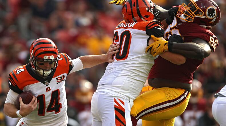 LANDOVER, MD - AUGUST 27: Quarterback Andy Dalton #14 of the Cincinnati Bengals rushes as teammate T.J. Johnson #60 blocks defensive tackle Stacy McGee #92 of the Washington Redskins in the second quarter during a preseason game at FedExField on August 27, 2017 in Landover, Maryland. (Photo by Patrick Smith/Getty Images)