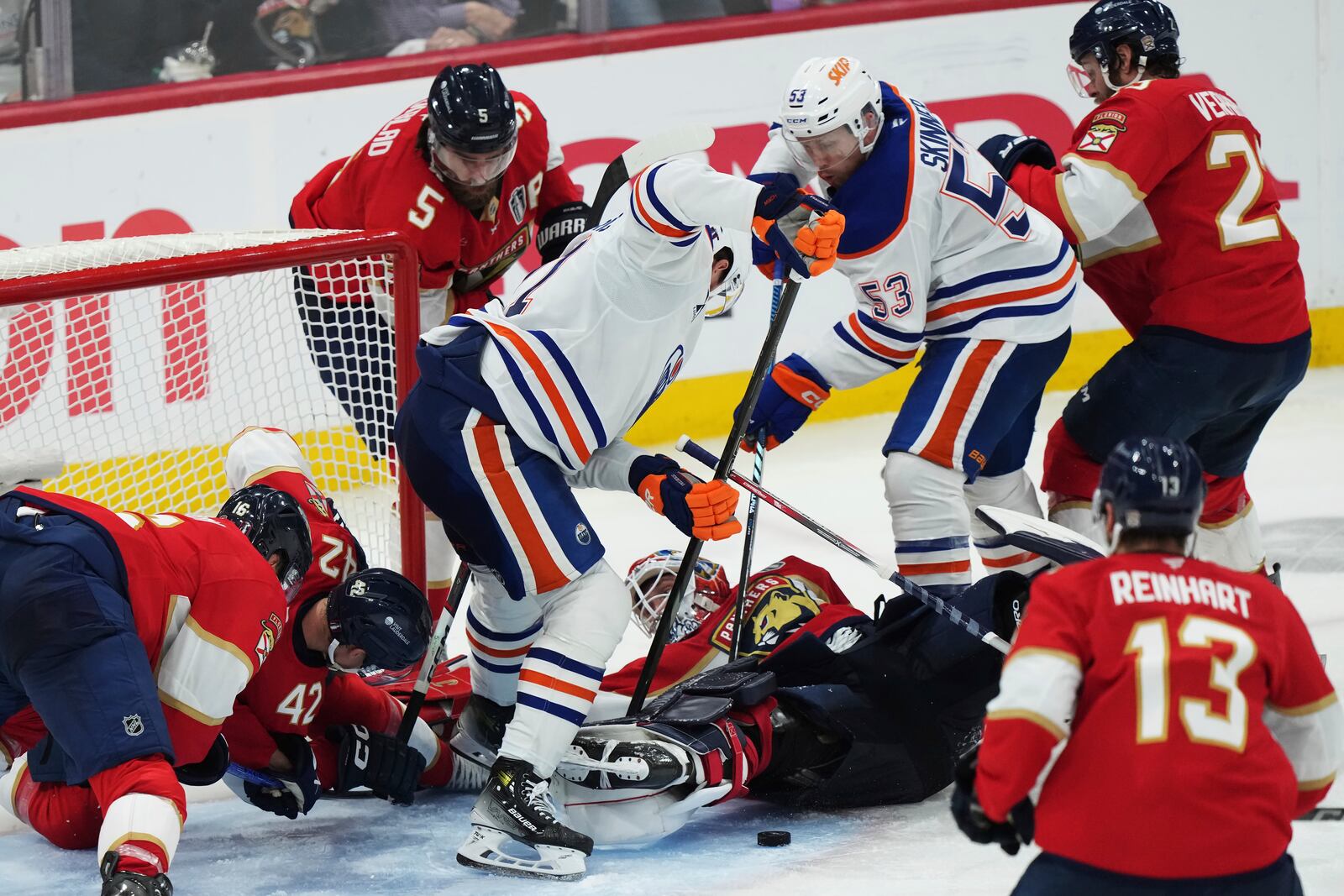 Florida Panthers goalie Sergei Bobrovsky, center bottom, makes a save as Edmonton Oilers' Trent Frederic, center, and Jeff Skinner (53) look for the puck during the first overtime period in Game 4 of the NHL hockey Stanley Cup Final in Sunrise, Fla., Thursday, June 12, 2025. (Nathan Denette/The Canadian Press via AP)