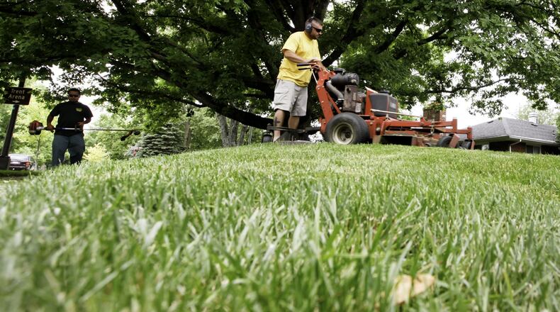 FILE PHOTO FROM 2013: Lawn care workers mow and trim a Kettering yard. CHRIS STEWART / STAFF