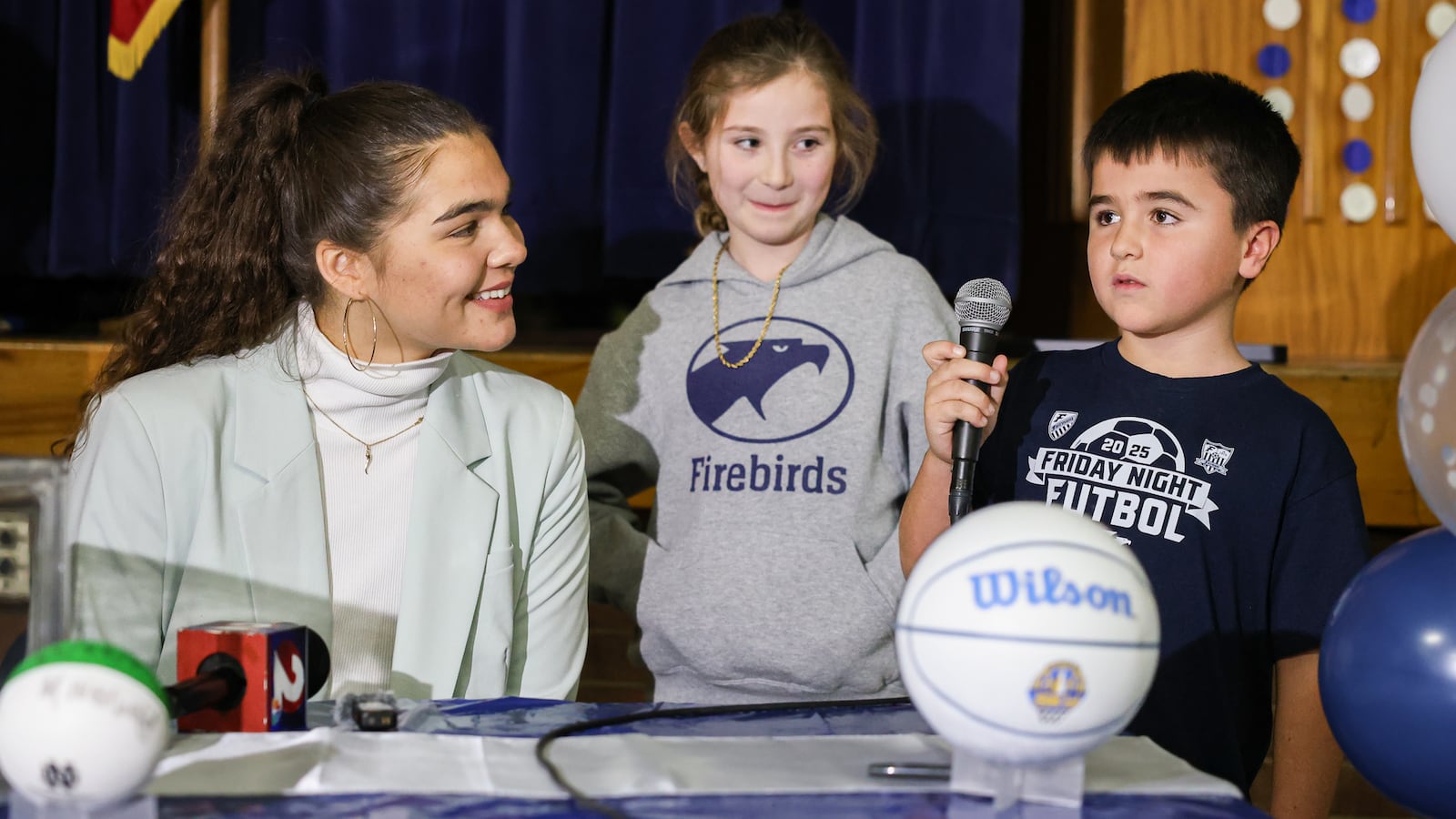 Maddy Westbeld (left), a Fairmont graduate who plays professional basketball for Chicago Sky, and Haiyden Tobias (center) listen to Carter Grasso (right) talk after an assembly at J.E. Prass Elementary School in Kettering on Friday, Dec. 12. Westbeld spoke to students, fielded questions from fifth grade student council members and recorded a video for Fairmont multimedia students along with Tobias, Grasso, Sienna Sheldon and Jackson Clark. BRYANT BILLING/STAFF