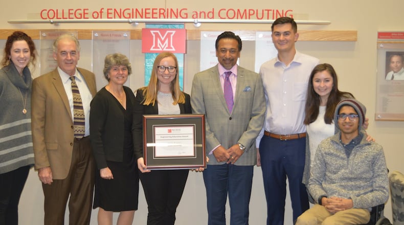 Engineers Without Borders President Anne Poindexter holds the certificate for the award the organization received for its water project in Uganda. The award was presented by Ferzan Ahmed, right of Anne, who came from Columbus to make the presentation. CONTRIBUTED/BOB RATTERMAN