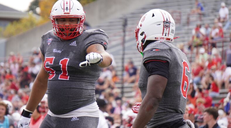 Miami’s Jordan Brunson (6) is congratulated by teammate Eric Smith after scoring a touchdown against Eastern Michigan on Saturday at Yager Stadium. CHRIS VOGT / CONTRIBUTED