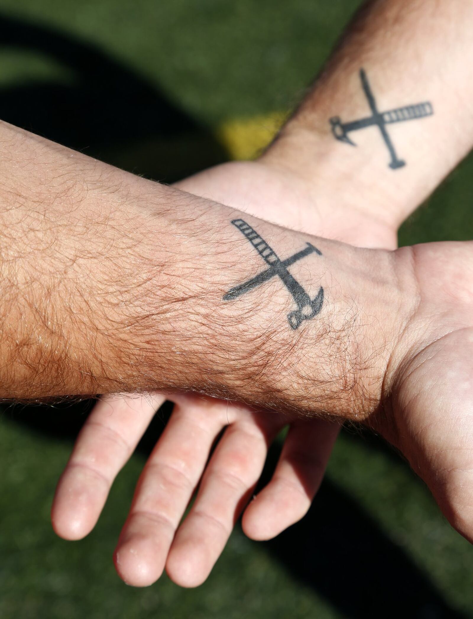 Tucker (left) and Drake Yinger play football for the University of Dayton. Earlier this year, their father, Dan Yinger, died in an accident cleaning down spouts. The family has matching tatoos of a hammer and nail. Dan Yinger told his sons each day to “be the hammer in life, not the nail.” Friends and family of the Yinger family honored Dan at Welcome Stadium on Saturday. LISA POWELL / STAFF