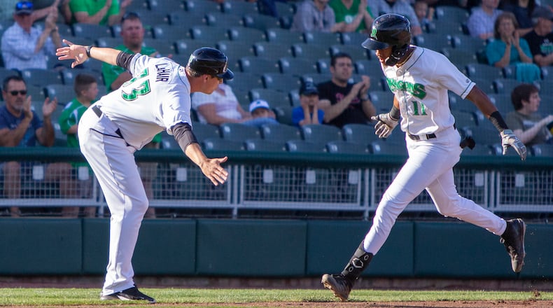 Dragons outfielder Justice Thompson rounds third and is greeted by manager Bryan LaHair after hitting a home run against Great Lakes last season. CONTRIBUTED/Jeff Gilbert