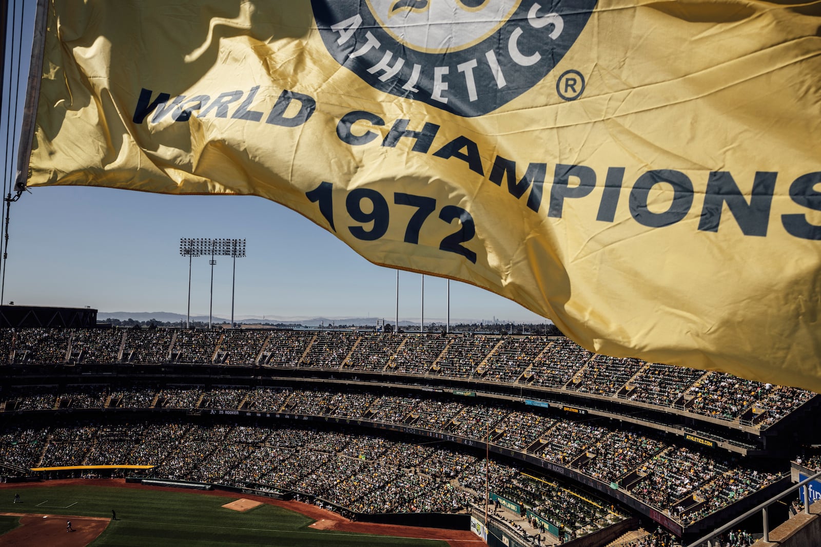 FILE - A 1972 world champions banner flies over the Oakland Coliseum during the Oakland Athletics' last home baseball game at the ballpark against the Texas Rangers in Oakland, Calif., Thursday, Sept. 26, 2024. (Stephen Lam/San Francisco Chronicle via AP, File)