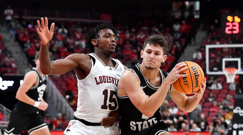 Wright State guard Keaton Norris (4) attempts to get past Louisville guard Hercy Miller (15) during the first half of an NCAA college basketball game in Louisville, Ky., Saturday, Nov. 12, 2022. (AP Photo/Timothy D. Easley)
