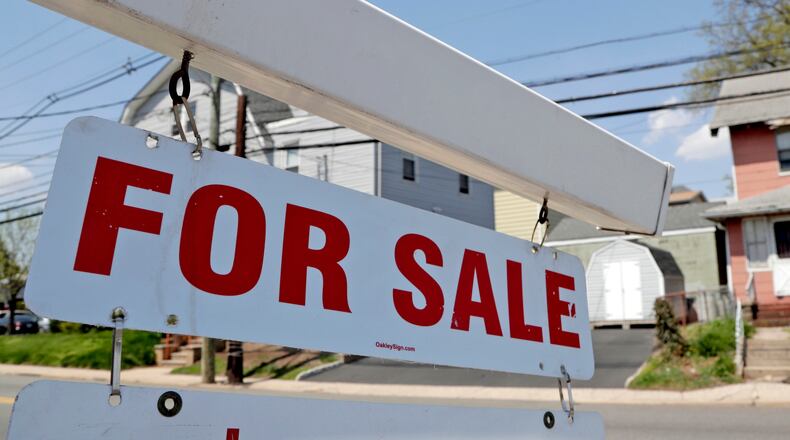 FILE - A "for sale" sign hangs from a post outside of a vacant business building in Belleville, N.J., Thursday, May 3, 2018. The Federal Reserve on Wednesday, July 27, raised its benchmark interest rate by a hefty three-quarters of a point for a second straight time in its most aggressive drive in three decades to tame high inflation. By raising borrowing rates, the Fed makes it costlier to take out a mortgage or an auto or business loan.(AP Photo/Julio Cortez, File)