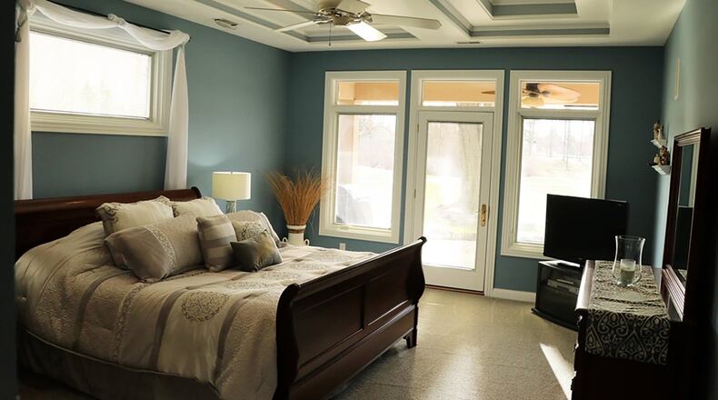 The main bedroom suite has coffered ceiling with updated carpeting and oversized patio doors that open to the covered rear porch that overlooks the 18th tee of Yankee Trace Golf Course. The walk-in closet has custom built cabinetry and a window seat.