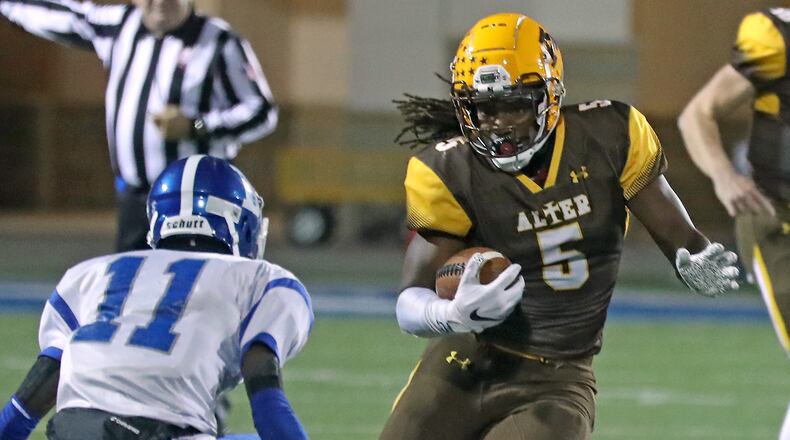 Alter's Branden McDonald tries to avoid a tackle by Dunbar's JaQuan Lusbourgh as he carries the ball. BILL LACKEY/STAFF