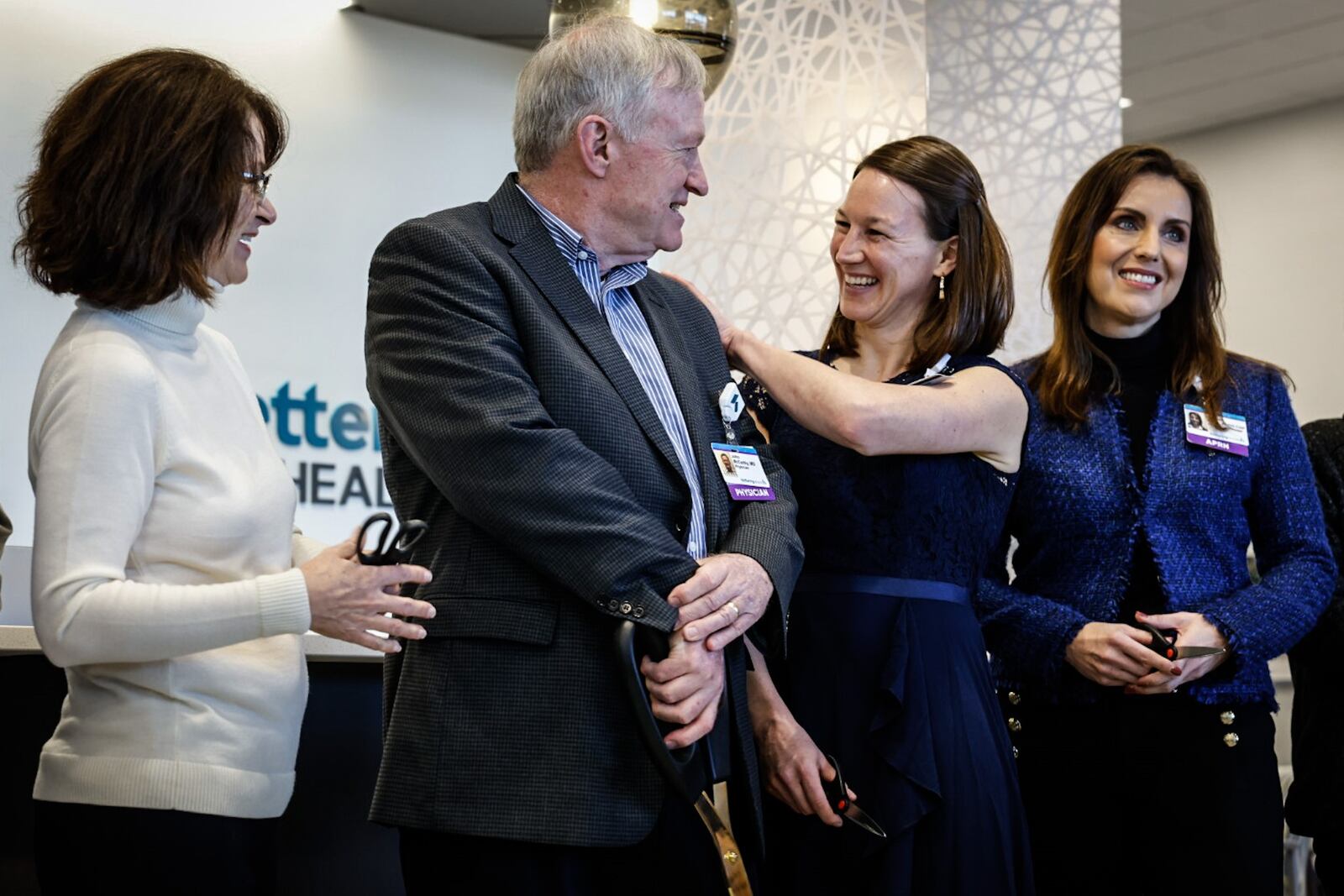 Dr. Jack McCarthy, center left, and Dr. Elaine Fogle, center right, both Kettering Health doctors, celebrate the opening of the new Centerville Health Center on Friday, Jan. 27, 2023. JIM NOELKER/STAFF