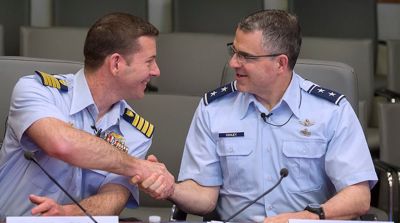 Coast Guard Capt. Greg Rothrock, left, commander of the Coast Guard Research and Development Center, and Maj. Gen. William Cooley, former commander of Air Force Research Lab, shake hands in April 2018 at Wright-Patterson Air Force Base after they signed a memorandum of understanding between their two organizations. (U.S. Air Force photo by R.J. Oriez)