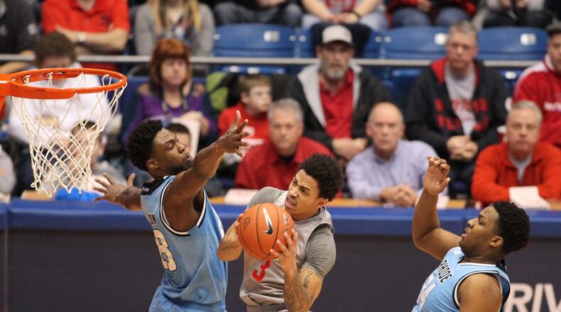 Dayton’s Kyle Davis shoots against Rhode Island’s Kuran Iverson, left, and Andre Berry, right, on Saturday, Feb. 27, 2016, at UD Arena in Dayton. David Jablonski/Staff